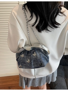 Deep blue denim cloud bag with silver butterfly charms and braided metal chain strap