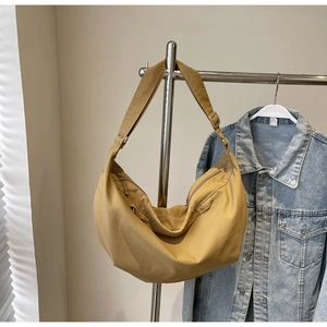 Detail view of khaki crescent shoulder bag with zipper closure and adjustable wide strap