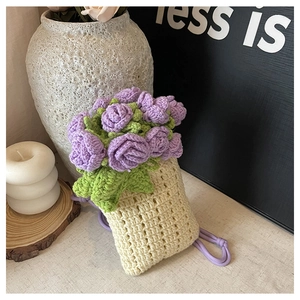 Dettaglio borsa a secchiello all'uncinetto con fiori viola e trama intrecciata crema