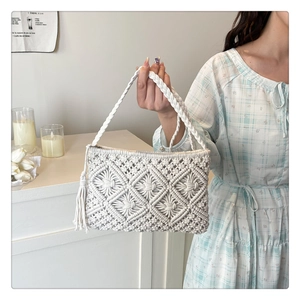 Close-up of minimalist hollow knit cotton crossbody bag with side fringe tassels