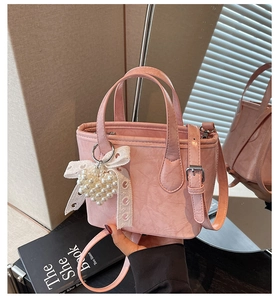 Dettaglio borsa a secchiello rosa in pelle PU vintage con cuore di perle e fiocco