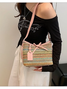 Colorful woven straw shoulder bag with pink leather trim and decorative bow detail