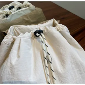 Dettaglio ravvicinato della chiusura a coulisse sulla borsa a secchiello leggera