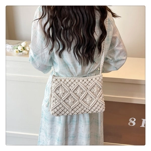 Detail of cream crochet crossbody bag with diamond patterns and decorative tassel