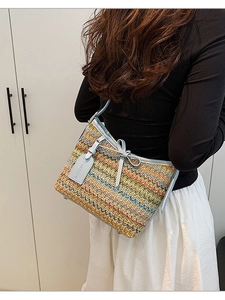 Colorful woven straw shoulder bag with light blue leather trim and a summer bow detail