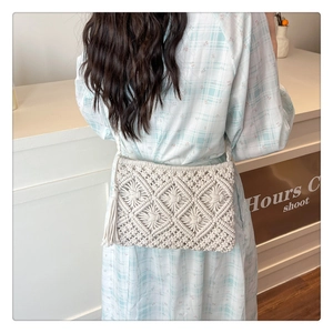 Close-up of beige macrame shoulder bag with geometric patterns and long side tassels
