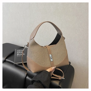 Detailed macro view of khaki leather texture and silver twist lock on the handbag