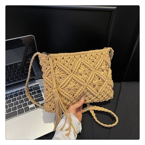 Close-up of khaki hollow knit crossbody bag with tassels and geometric woven patterns