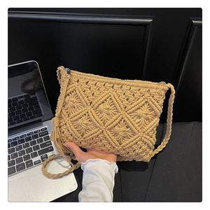 Close-up of beige crochet crossbody bag showing diamond hollow patterns and tassel detail