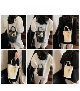 Gedetailleerde weergave van de minimalistische bucket bag voor dames met hanger in zwart en crème