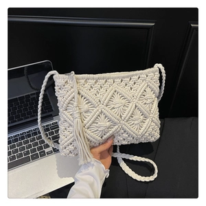Detail of white crochet crossbody bag with diamond weave pattern and tassel charm