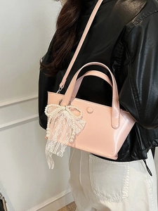 Borsa a secchiello rosa in pelle PU con fiocco in pizzo e perle indossata da modella
