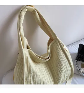 Macro detail of creamy yellow pleated fabric tote bag with soft texture and wide handles
