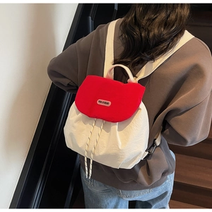 Detail view of red and white nylon backpack with drawstring and adjustable buckle closures