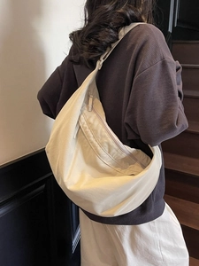 Minimalist beige dumpling bag with adjustable strap in a spacious crescent design