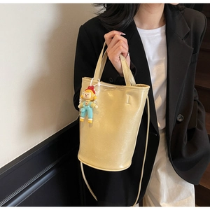 Détail du sac seau crème texture crocodile avec gaufrage mode et breloque dessin animé