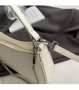 Close-up of cream white PU leather bag with silver metal chain and buckle detail