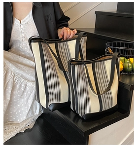 Detail of black and white striped canvas tote bags in large and small sizes with leather base