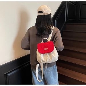 Rear view of model wearing contrast color drawstring backpack on wooden stairs