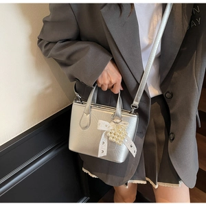 Mini borsa a secchiello argento con fiocco in pizzo bianco e ciondolo a cuore di perle