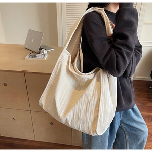 Detail of a large cream crossbody bag with a unique crinkled fabric texture for women