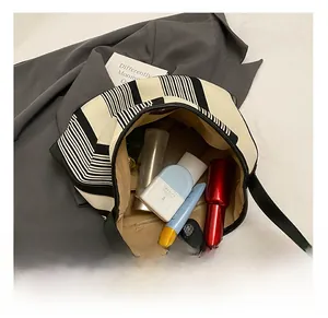 Detail view of large capacity striped canvas tote bag interior with magnetic buckle