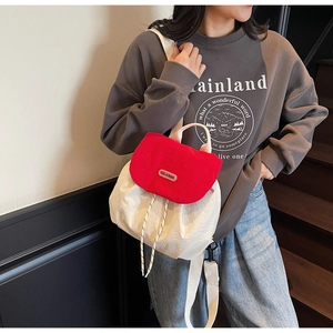 Detail of red and cream backpack showing drawstring closure and brand label