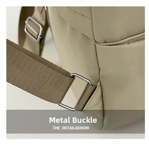 Detail view of silver hardware ring and stitching on khaki waterproof backpack strap