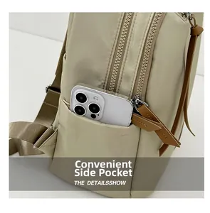 Detail view of a beige nylon backpack featuring a convenient side pocket with zipper closure