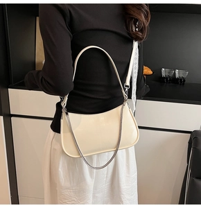 Chic cream white leather underarm bag with silver chain strap shown on a model