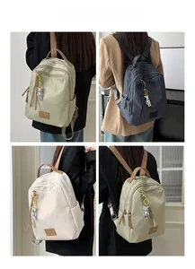 Detail view of waterproof nylon travel backpacks with adjustable straps and bear pendant