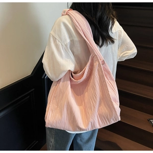 Detail showing the pink wrinkled fabric and large capacity of this casual tote bag