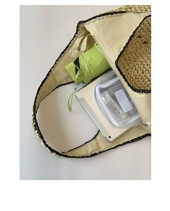 Large straw tote bag detail showing high capacity with umbrella and tablet inside