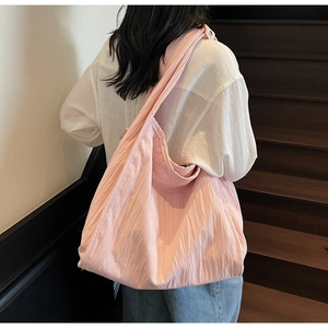 Detail of pink pleated tote bag showing large capacity and soft textured fabric in use
