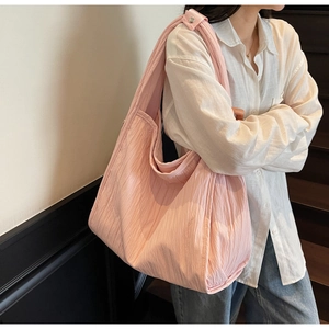 Detail of pink textured pleated tote bag showing fabric texture and spacious interior