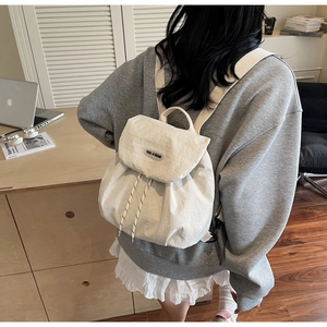 Detailed close-up of a beige waterproof nylon backpack with a drawstring closure and logo
