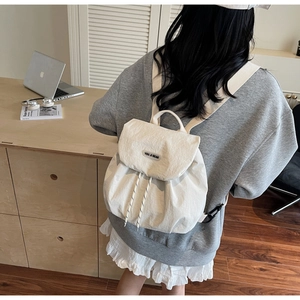 Detailed back view of casual off-white nylon drawstring backpack on a model