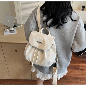 Detail of off-white drawstring backpack with YOU JI BEAR label and secure back zipper
