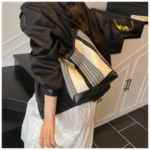 Detail of black and white striped canvas tote bag with reinforced leather base and edges