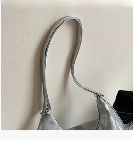 Close-up of silver high-gloss tote bag with metallic zipper and slender straps