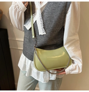 Detail view of light green leather shoulder bag with silver chain and adjustable strap