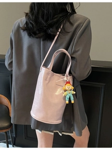 Sac seau chic en cuir violet clair avec pendentif poupée et bandoulière réglable