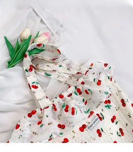 Close-up of white cherry print tote bag with ruffled edges and Magic Pocket label