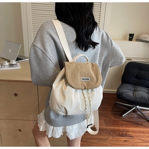 Detail of a large capacity cream and khaki drawstring backpack shown on a model
