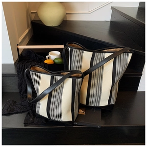 Detail showing high-quality black and white striped canvas texture with faux leather edges