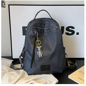 Detail view of water-resistant nylon backpack with multi-compartments and bear charm