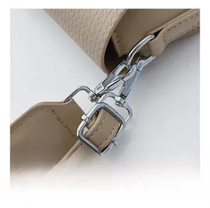 Close-up of wavy embossed leather texture and silver metallic hardware on shoulder bag