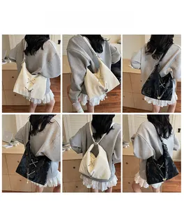 Detail of hobo bag featuring silver crisscross straps and delicate butterfly pearl charms