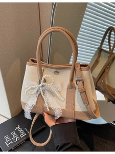 Elegant white and tan bucket bag with pearl lace bow and adjustable shoulder strap