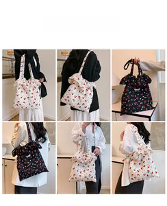 Detail view of canvas tote bag with cherry print and ruffled edge in black and white